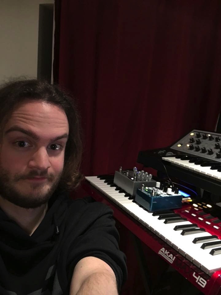 A closeup of a man beside an electric organ